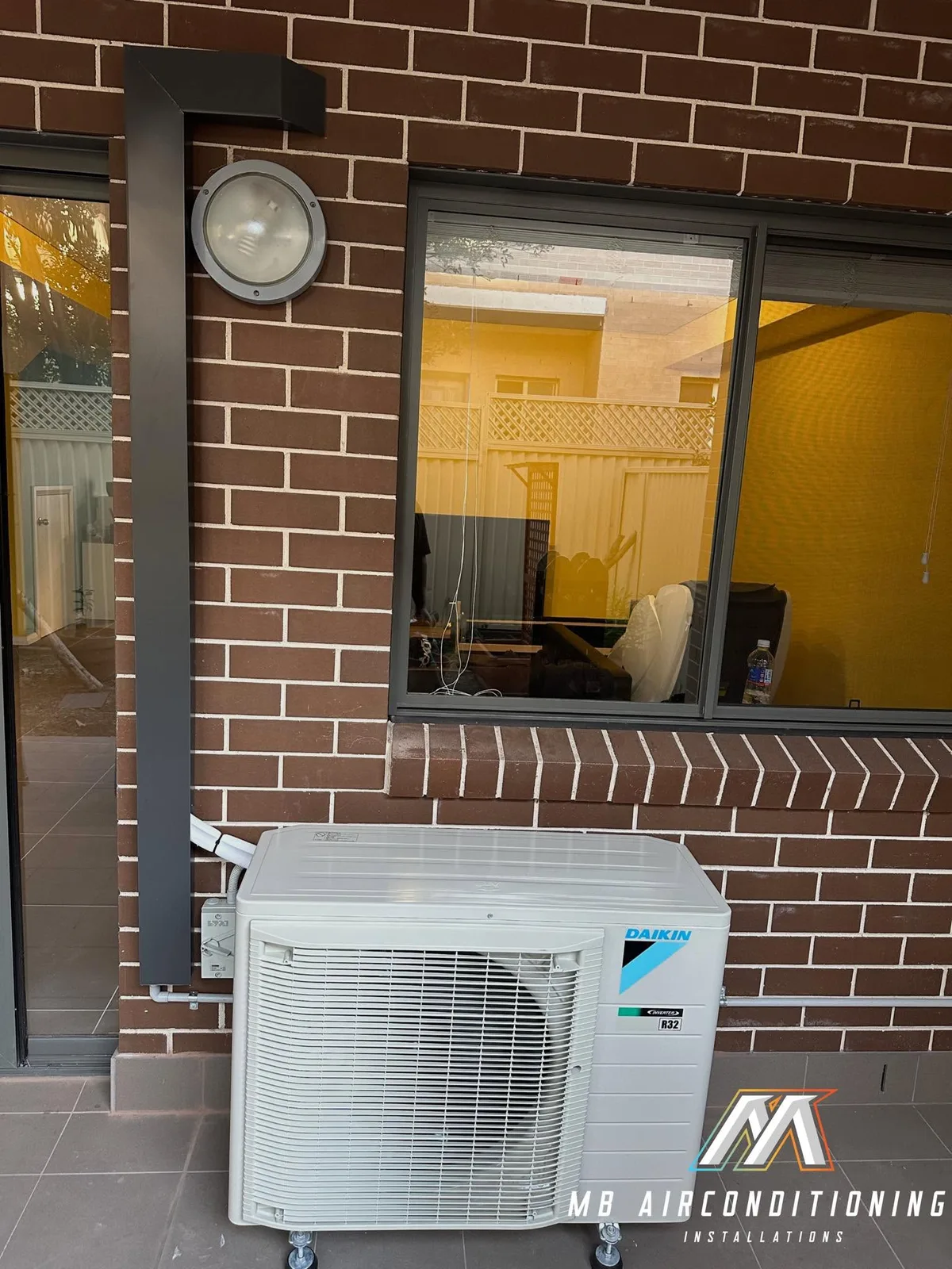 Daikin outdoor unit beside a brick wall