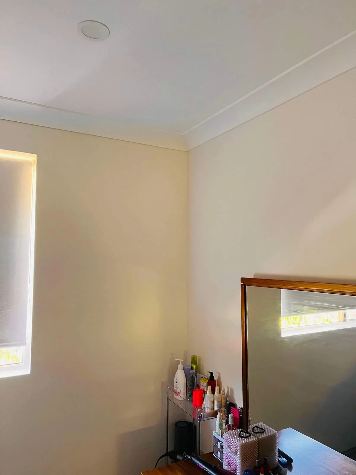 Circular ducted air conditioning outlet in a bedroom ceiling