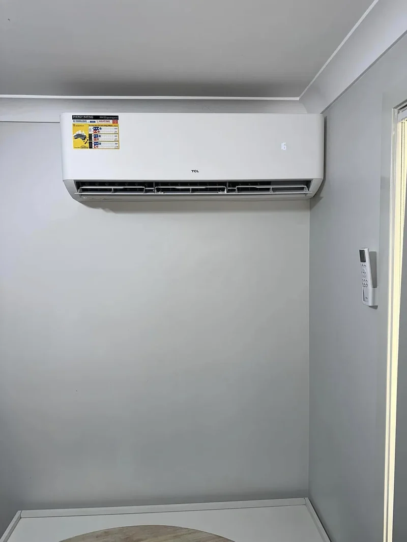 Wall-mounted split system installed in a hallway, pipework run neatly to the outside wall