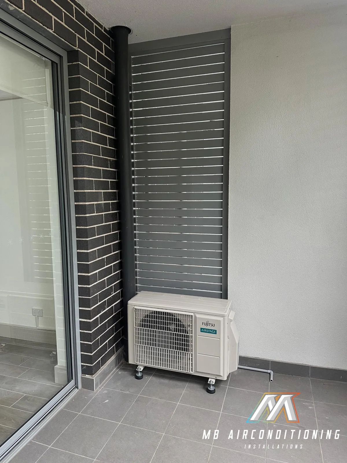 Outdoor air conditioning unit beside a screened window