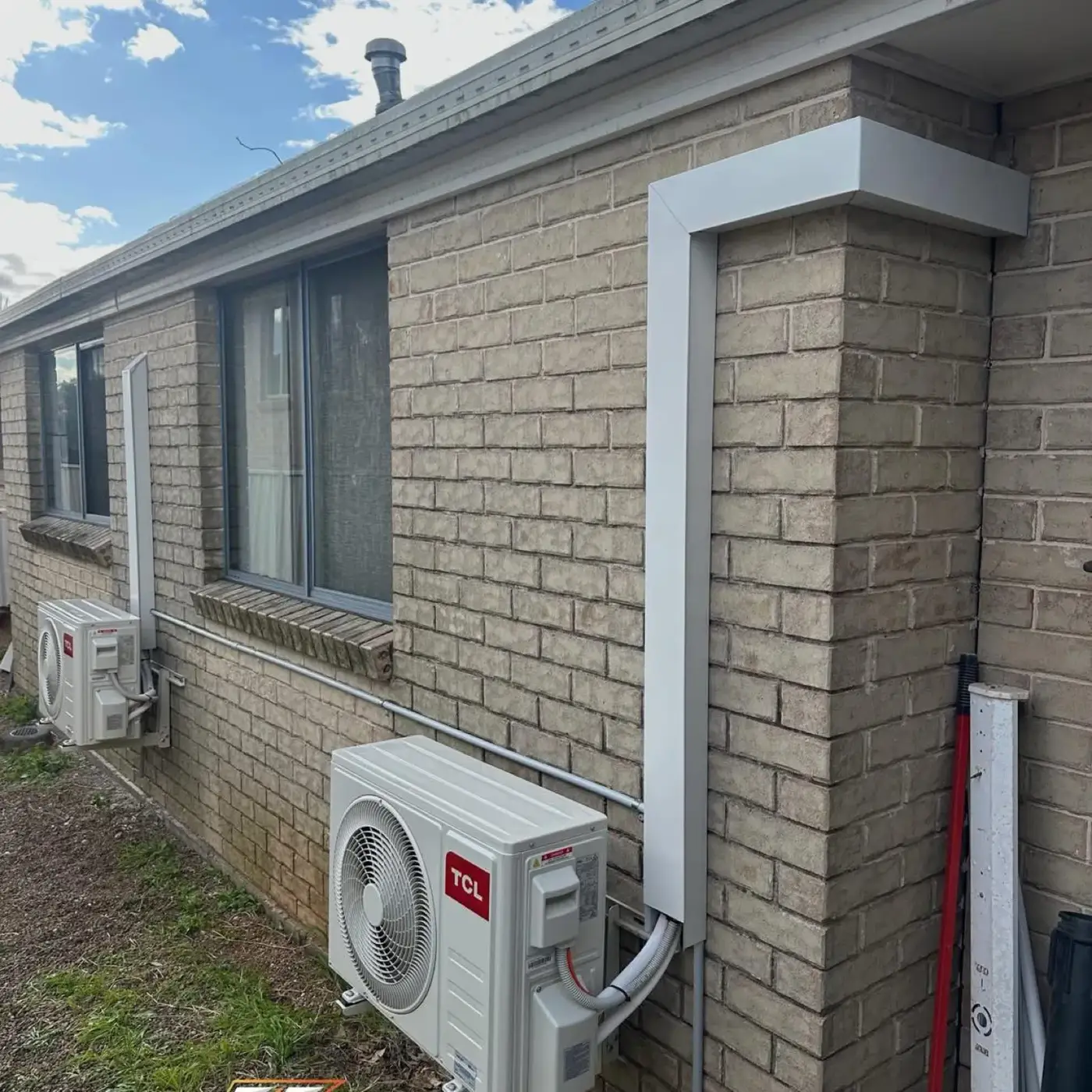 Outdoor air conditioning units beside a brick home