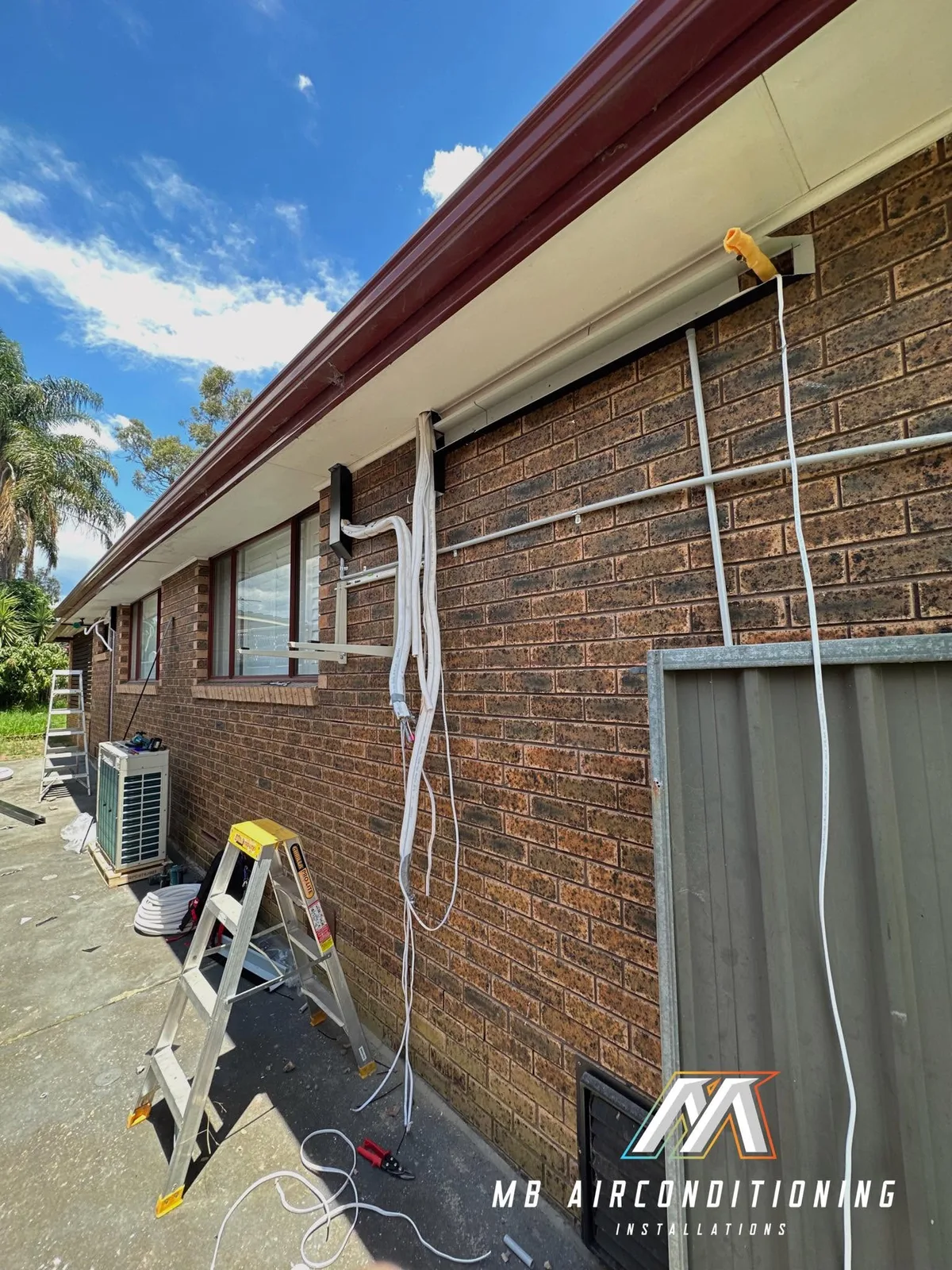 Exterior pipework and mounting brackets during installation at a brick home