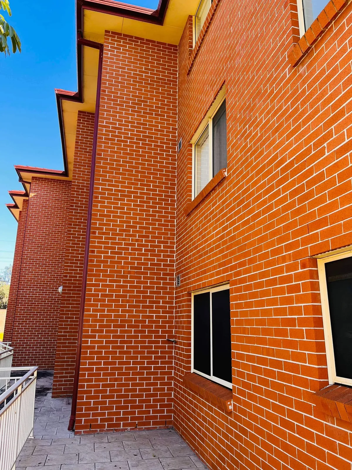 Exterior pipe cover on a two-storey brick home